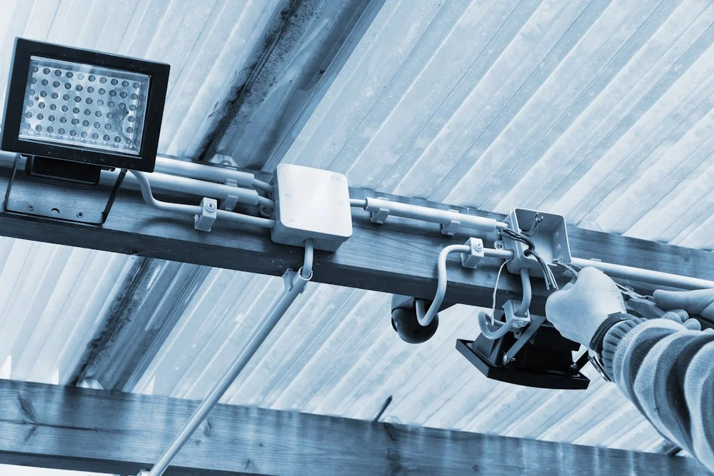 Person installiert Überwachungskamera mit LEDs.