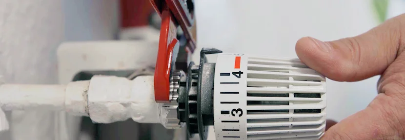 Person dreht Heizung herunter