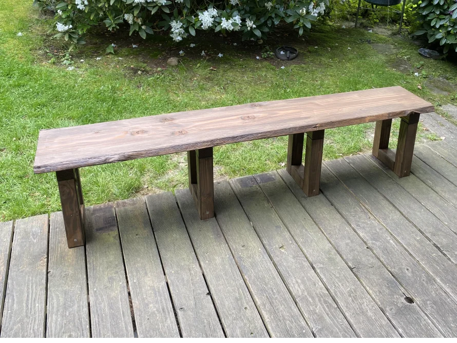 Dunkel gebeizte Holzbank auf Terrasse