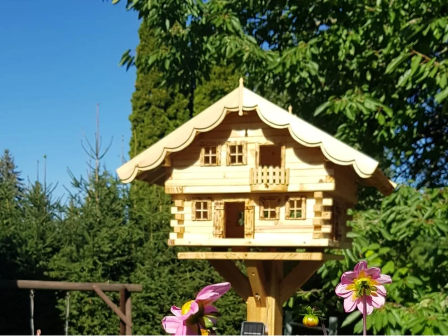 Vogelhaus im Blockhausstil auf einem Ständer