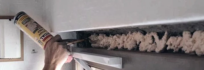 Person trägt Bauschaum mit einer Spritzpistole auf