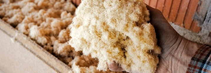 Person hält Dämmmaterial zur Einblasdämmung in der Hand