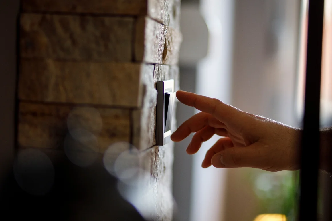 Hand betätigt einen Lichtschalter.