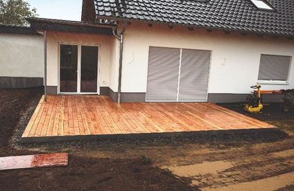 Abschlusskante aus Metall für Holzterrasse Eine frisch gebaute Holzterrasse mit einer Abschlusskante aus Metall.