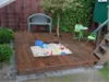 Sandkasten auf Holzterrasse mit Spielzeug
