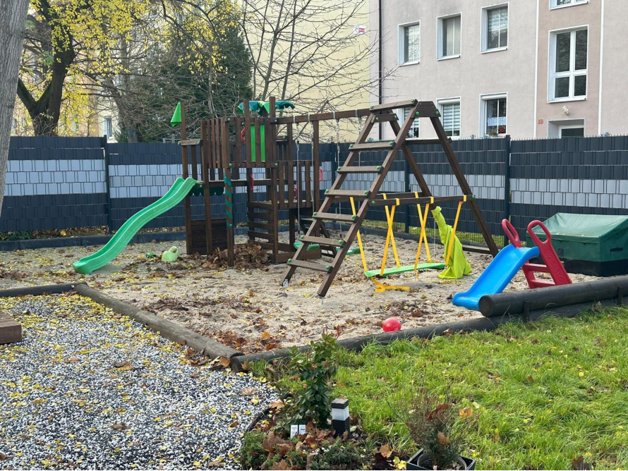 Spielplatz im Garten mit Rutsche und Schaukel