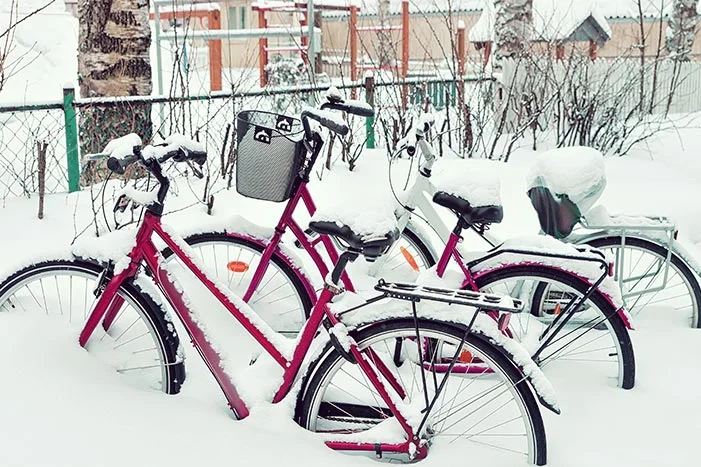 Drei Fahrräder im Schnee.
