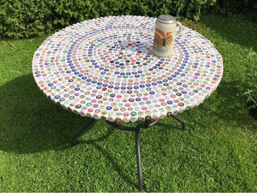 Runder Tisch mit Bierdeckeln beklebt