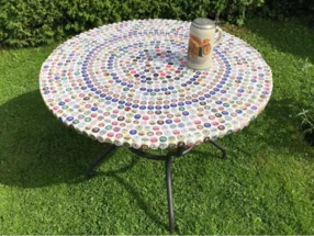 Runder Tisch mit Bierdeckeln beklebt