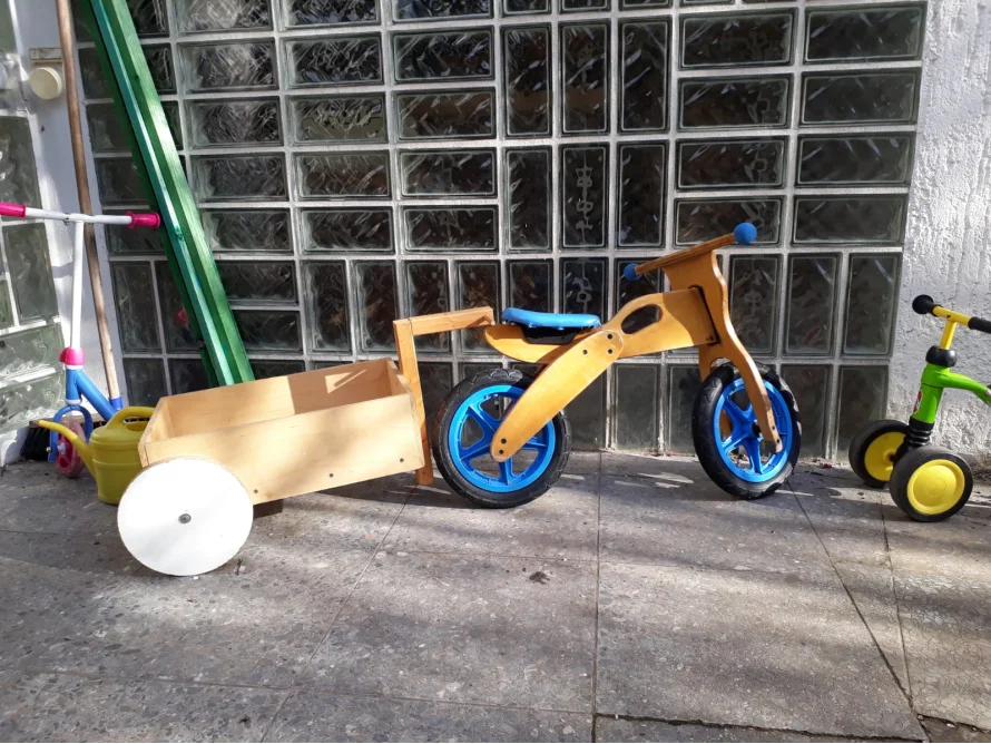 Holzlaufrad mit Anhänger und Kinderspielzeug