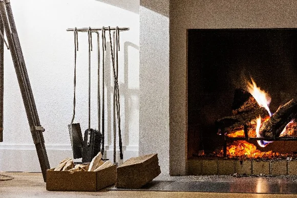 Kaminbesteck und brennendes Kaminfeuer