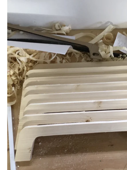 Gebogene Holzlatten und Säge