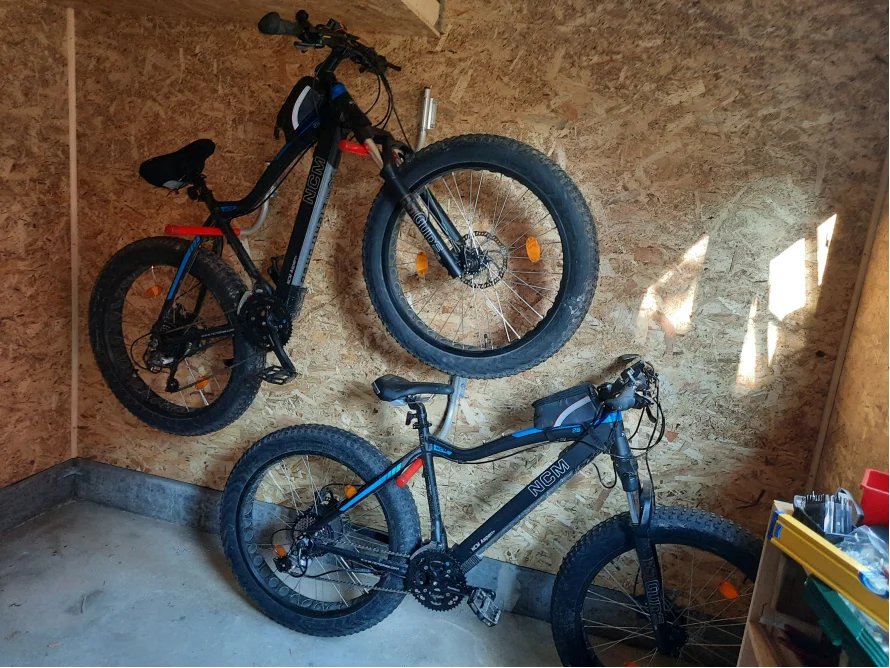 Zwei Fahrräder hängen an einer Wand.