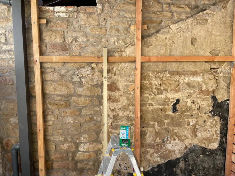 Holzrahmen an Steinwand mit Wasserwaage