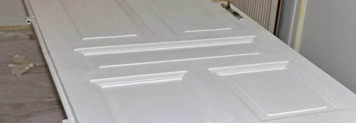 Eine frisch gestrichene weiße Tür liegt auf zwei Böcken.