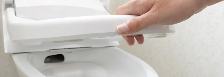 Person öffnet Toilettensitz