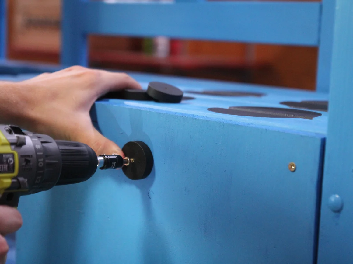 Person befestigt etwas mit einem Akkuschrauber