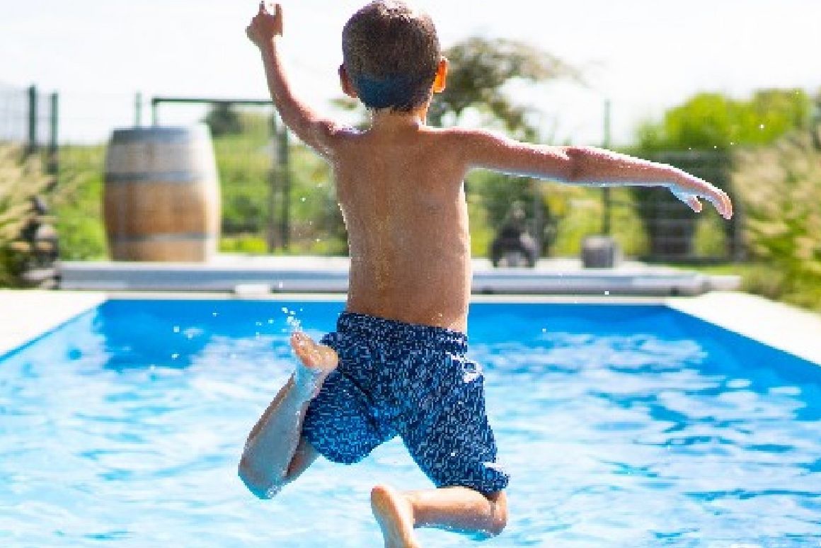Kind springt in Pool