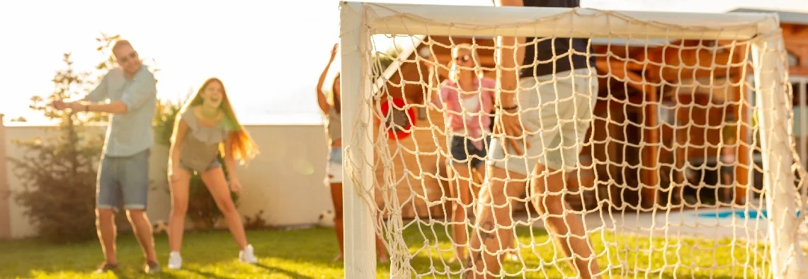 Menschen spielen Fußball im Garten