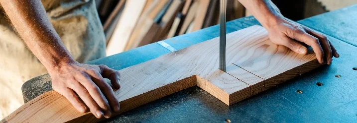 Person sägt Holz mit Bandsäge