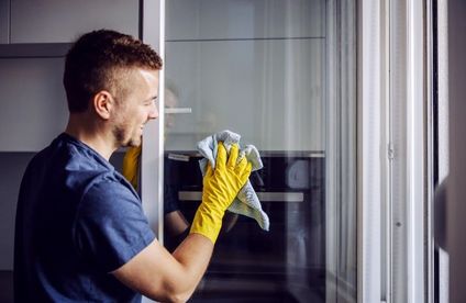 Mann putzt Fenster