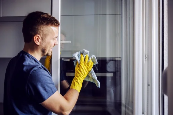 Person reinigt mit Tuch eine Backofentür
