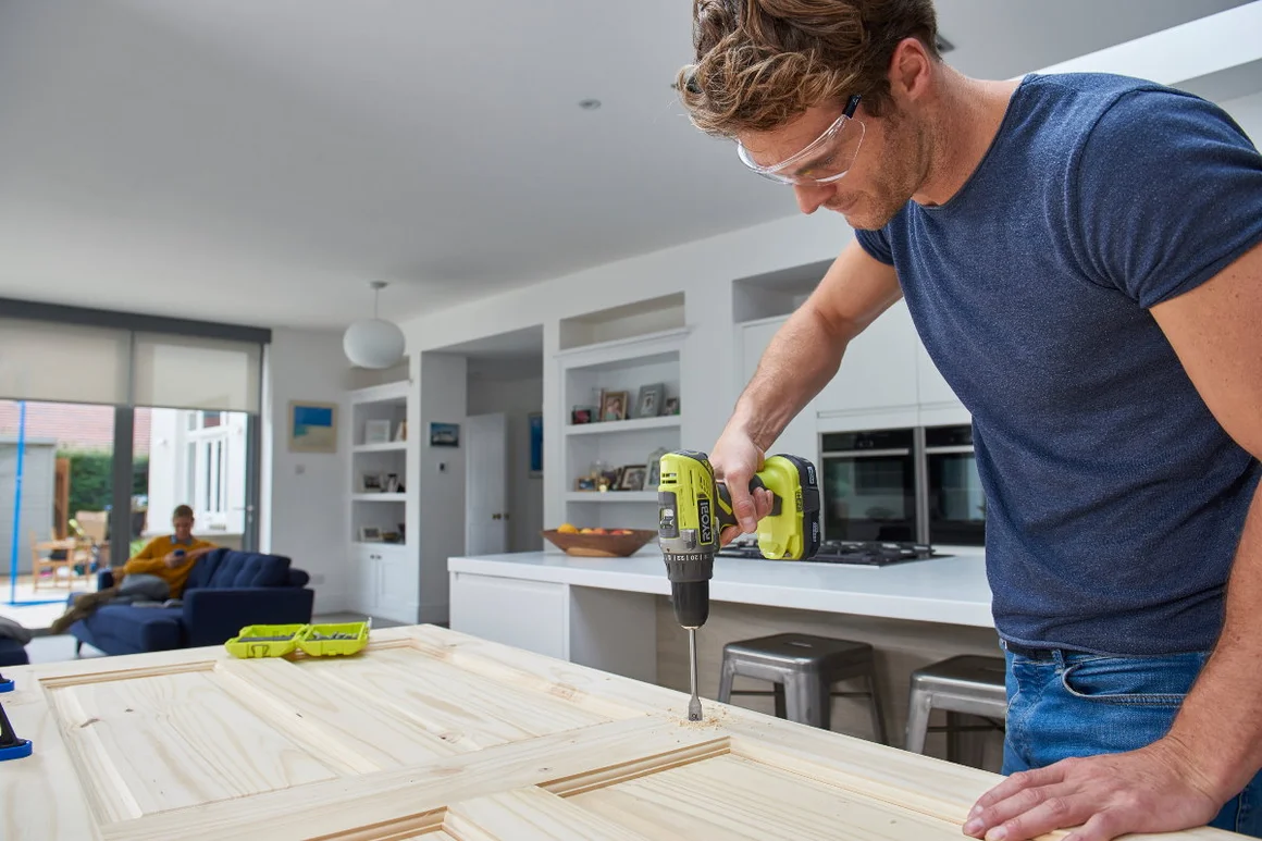 Person baut mit Akkuschrauber eine Holztür zusammen