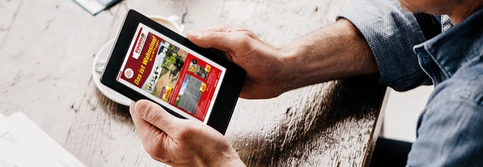 Eine Person liest einen digitalen Prospekt auf einem Tablet.