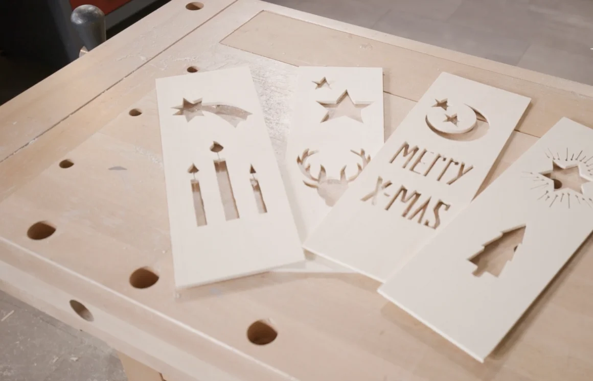 Weihnachtliche Holzschablonen auf Werkbank