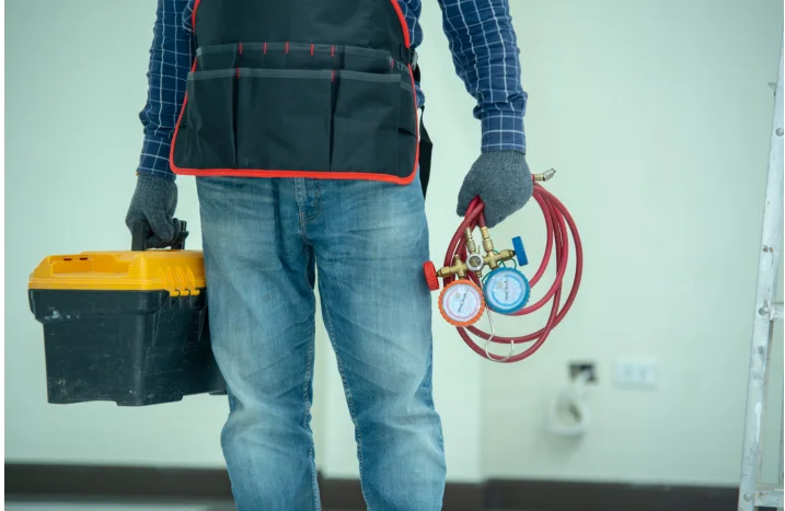 Handwerker mit Werkzeugkoffer und Monteurhilfe.