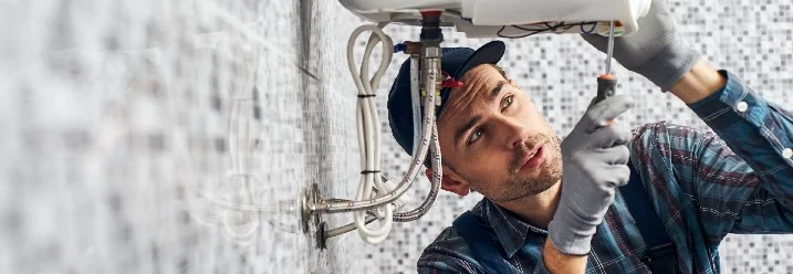 Person repariert Boiler mit Schraubendreher