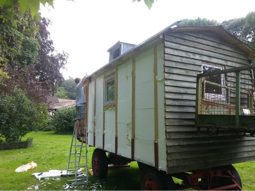 Person baut einen Bauwagen