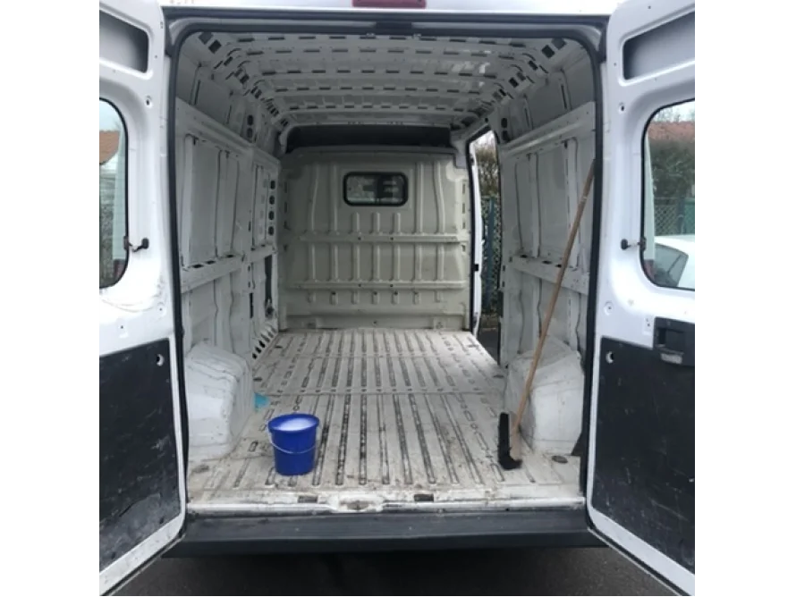 Leerer Laderaum eines Lieferwagens mit Besen