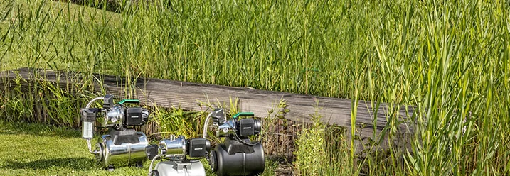 Drei Wasserpumpen auf einem Rasen