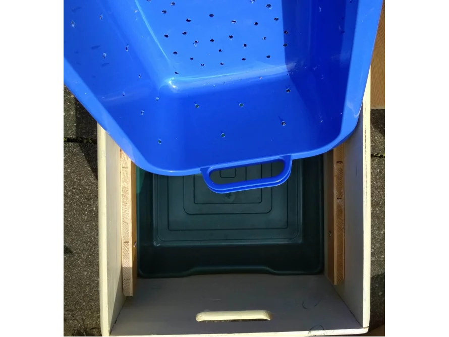 Blaue Plastikwanne in Holzkiste