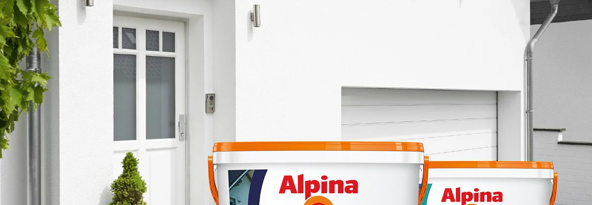 Drei Farbeimer vor einem weißen Haus