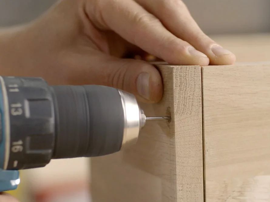 Person verschraubt Holz mit Akkuschrauber