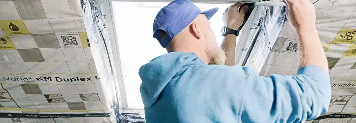 Person montiert Dachfenster