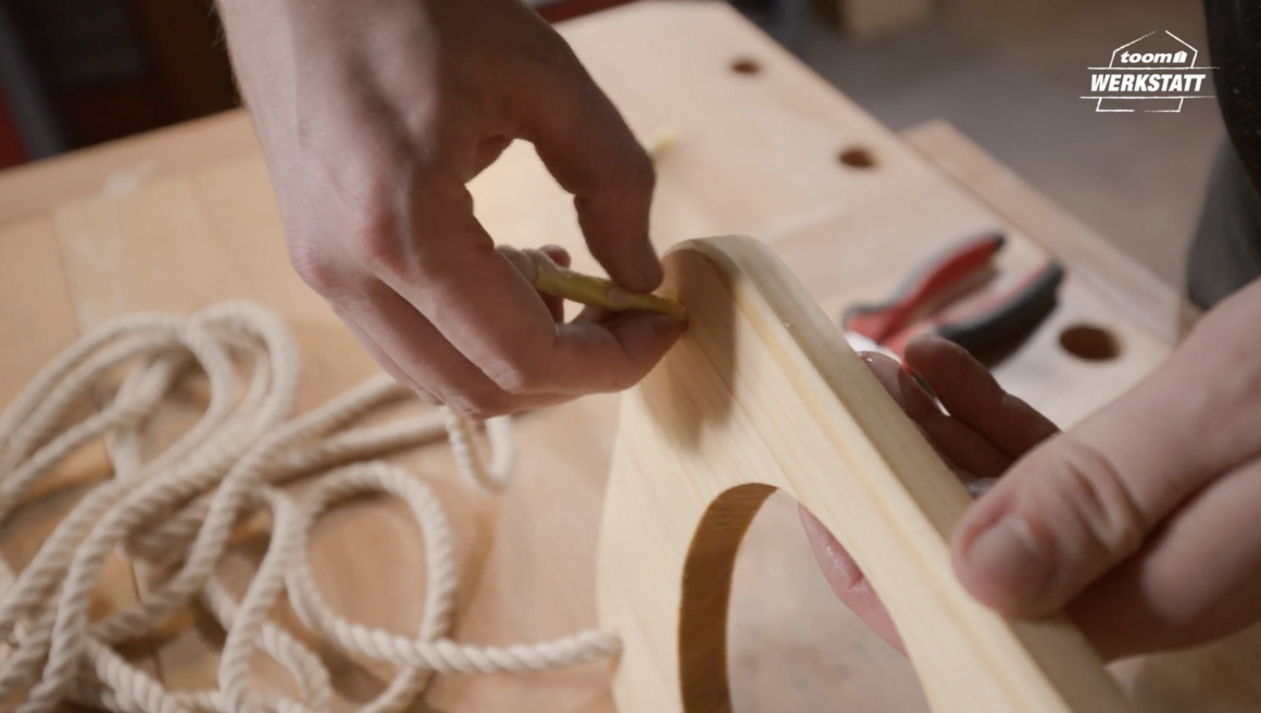 Person markiert Holz mit Bleistift