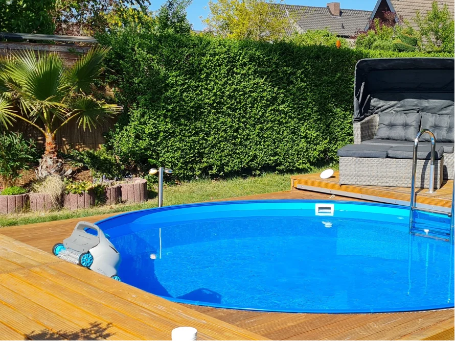 Blauer Pool im Garten mit Reinigungsroboter