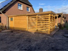 Holzgerüst eines Gartenhauses an einem Haus