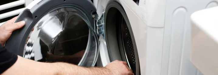 Person öffnet Tür einer Waschmaschine