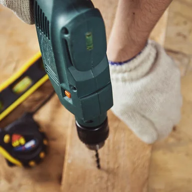 Bohrmaschine bohrt in Holzbrett