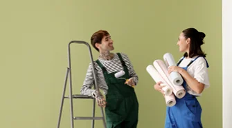 Person trägt Kleister mit Pinsel auf Tapete auf