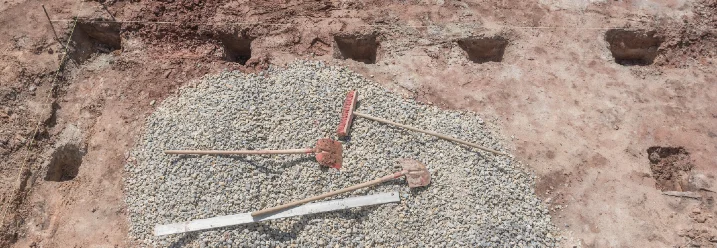 Baugrube mit Kies und Werkzeug