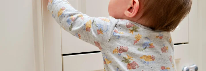 Kleinkind öffnet Schranktür