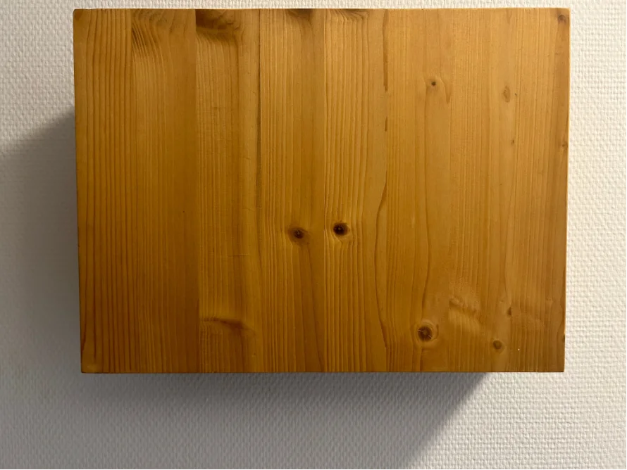 Rechteckiges Holzbrett an der Wand