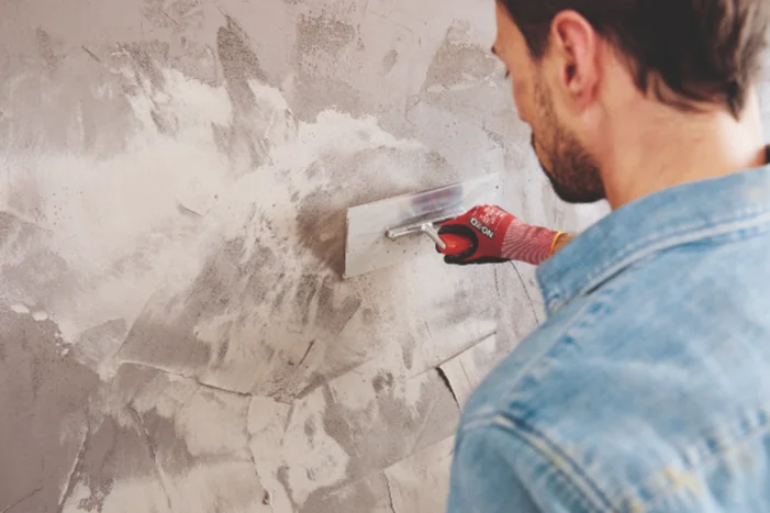 Person verputzt Wand