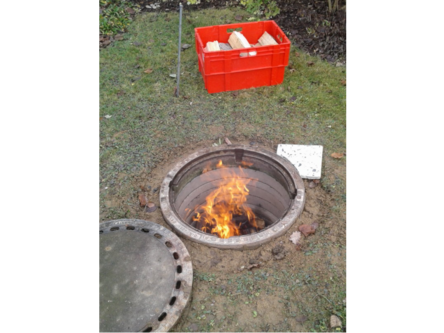 Feuer brennt in einem Loch im Boden