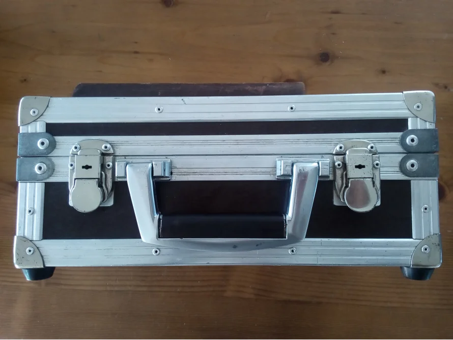 Ein silberner Werkzeugkoffer mit schwarzen Griffen.